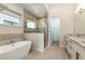 Bathroom showcasing a modern tub, separate shower, and a door to walk-in closet at 7928 Jacks Club Dr, Kissimmee, FL 34747