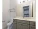 This bathroom features a spacious vanity, toilet, and a large mirror, with a glimpse into the laundry room at 7928 Jacks Club Dr, Kissimmee, FL 34747