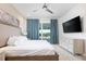 Modern bedroom with large bed, TV, backyard view, and elegant blue curtains at 7928 Jacks Club Dr, Kissimmee, FL 34747