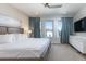 Stylish bedroom with large windows, television, and elegant blue curtains at 7928 Jacks Club Dr, Kissimmee, FL 34747