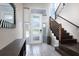Bright foyer features modern door with glass inserts, staircase, and tiled floor at 7928 Jacks Club Dr, Kissimmee, FL 34747