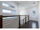Upstairs hallway features dark wood floors, horizontal railings, and transom windows at 7928 Jacks Club Dr, Kissimmee, FL 34747