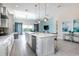Bright, open kitchen with island, stainless steel appliances and pendant lighting overlooking the living area at 7928 Jacks Club Dr, Kissimmee, FL 34747