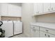 This laundry room features modern appliances, white cabinetry, and ample counter space for folding and sorting laundry at 7928 Jacks Club Dr, Kissimmee, FL 34747