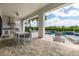 Covered patio with outdoor kitchen, dining area, and lounge chairs overlooking the pool and lush landscaping at 7928 Jacks Club Dr, Kissimmee, FL 34747