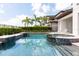 Resort-style pool and spa with mosaic tile accents and lush landscaping at 7928 Jacks Club Dr, Kissimmee, FL 34747