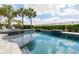 Swimming pool and spa featuring a decorative mosaic tile trim and views of the manicured landscaping beyond at 7928 Jacks Club Dr, Kissimmee, FL 34747