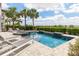 This beautiful backyard features a swimming pool, hot tub, lounge chairs, and lush landscaping for outdoor enjoyment at 7928 Jacks Club Dr, Kissimmee, FL 34747