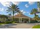 Community clubhouse with palm trees against a blue sky at 8107 Coconut Palm Way # 102, Kissimmee, FL 34747