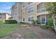 A tan condo building with a screened-in patio and a small garden area at 8107 Coconut Palm Way # 102, Kissimmee, FL 34747