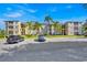 Condo complex with palm trees and parking area under a blue sky at 8107 Coconut Palm Way # 102, Kissimmee, FL 34747