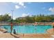 Community outdoor swimming pool with sun loungers and palm trees at 8107 Coconut Palm Way # 102, Kissimmee, FL 34747
