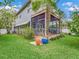Spacious backyard with lush green lawn, screened in patio with multiple chairs, and potted plants at 811 Laurel Ave, Orlando, FL 32803
