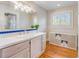 Bathroom with wood floors, white cabinets, double sinks, and natural light at 811 Laurel Ave, Orlando, FL 32803