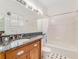 Bright bathroom features a single sink vanity with dark granite top, shower-tub combination with tiled walls at 811 Laurel Ave, Orlando, FL 32803