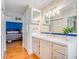 Bathroom with wood floors, white cabinets, double sinks, and plant at 811 Laurel Ave, Orlando, FL 32803