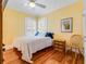 Bedroom featuring a queen-sized bed, wood floors, neutral walls and ample natural light from shuttered windows at 811 Laurel Ave, Orlando, FL 32803