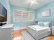 Cozy bedroom in light blue hues with hardwood floors, a metal bed frame, and plenty of natural light at 811 Laurel Ave, Orlando, FL 32803