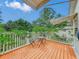 Outdoor wooden deck showcasing a table and chairs, surrounded by white railings, and lush green foliage at 811 Laurel Ave, Orlando, FL 32803