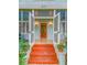 Inviting front entrance with vibrant steps, louvered doors, and vintage-style sconce lighting at 811 Laurel Ave, Orlando, FL 32803