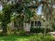 A cozy home facade with a screened porch, framed by lush greenery and trees, exuding a serene, private ambiance at 811 Laurel Ave, Orlando, FL 32803