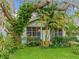 Charming home exterior with lush landscaping, a screened porch, and mature trees offering shade at 811 Laurel Ave, Orlando, FL 32803