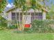 Home exterior featuring a screened porch with painted steps, surrounded by mature landscaping and palm trees at 811 Laurel Ave, Orlando, FL 32803