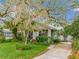 Exterior shot of a house with a mature oak tree, lawn, and a driveway leading to the rear at 811 Laurel Ave, Orlando, FL 32803