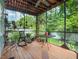 Relaxing screened in porch with an open ceiling, potted plants, chairs and a table overlooking a lush backyard at 811 Laurel Ave, Orlando, FL 32803