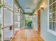 Sun porch with tile flooring, sky blue ceiling, green wicker chair and open louvered doors at 811 Laurel Ave, Orlando, FL 32803