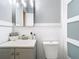 Modern bathroom features a gray vanity, updated fixtures, and a decorative mirror at 844 Rosalia Dr, Sanford, FL 32771