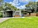 Charming single-story home featuring a covered carport and front porch, enhanced by a well-manicured lawn at 844 Rosalia Dr, Sanford, FL 32771