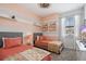 Charming bedroom with twin beds, decorative pillows, and peach and white striped walls at 8549 Zoeller Hills Dr, Davenport, FL 33896