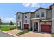 Charming townhome exterior with brick driveway, lake view, and red garage door at 8549 Zoeller Hills Dr, Davenport, FL 33896