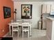Dining area with a white table and chairs, adjacent to the kitchen with a fire extinguisher at 2524 Grassy Point Dr # 104, Lake Mary, FL 32746