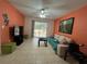 Living room with tile flooring, sliding glass doors to the patio, orange accent wall, and ceiling fan at 2524 Grassy Point Dr # 104, Lake Mary, FL 32746