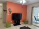 Cozy living room with tiled floors, ceiling fan, orange accent wall, and sliding glass doors to the patio at 2524 Grassy Point Dr # 104, Lake Mary, FL 32746
