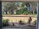 View of the lush backyard and landscaping from the screened-in lanai at 2524 Grassy Point Dr # 104, Lake Mary, FL 32746