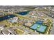 An aerial view of the community, showing tennis courts, playground, clubhouse, and lake at 10209 Folly Beach Rd, Orlando, FL 32827