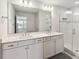 Bathroom featuring dual sinks, a large mirror and a glass enclosed shower at 10209 Folly Beach Rd, Orlando, FL 32827