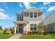 Charming two-story home featuring a quaint front porch and well-manicured lawn under a bright sky at 10209 Folly Beach Rd, Orlando, FL 32827