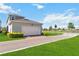 Two-car garage with brick-paved driveway, green lawn and tidy landscaping at 10209 Folly Beach Rd, Orlando, FL 32827