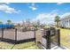 Community playground with slides and climbing structures, enclosed by black metal fencing at 10209 Folly Beach Rd, Orlando, FL 32827