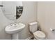 Clean and modern powder room with a pedestal sink and round mirror at 10209 Folly Beach Rd, Orlando, FL 32827