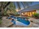 Gorgeous backyard pool with stone features, a hot tub, and serene lighting at twilight at 1130 Roxboro Rd, Longwood, FL 32750