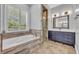 Bathroom with a large soaking tub, double vanities, and walk-in shower with glass door at 1130 Roxboro Rd, Longwood, FL 32750