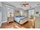 Primary bedroom featuring a ceiling fan, wood floors, and a barn door leading to the bathroom at 1130 Roxboro Rd, Longwood, FL 32750