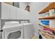 Functional laundry room equipped with washer, dryer, and convenient storage shelves at 1130 Roxboro Rd, Longwood, FL 32750