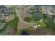 Panoramic aerial shot showcases vast land with a central dirt road leading to a secluded estate with a pond at 11320 Montevista Rd, Clermont, FL 34711