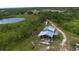 Expansive aerial view of the property featuring a tranquil pond and lush greenery at 11320 Montevista Rd, Clermont, FL 34711